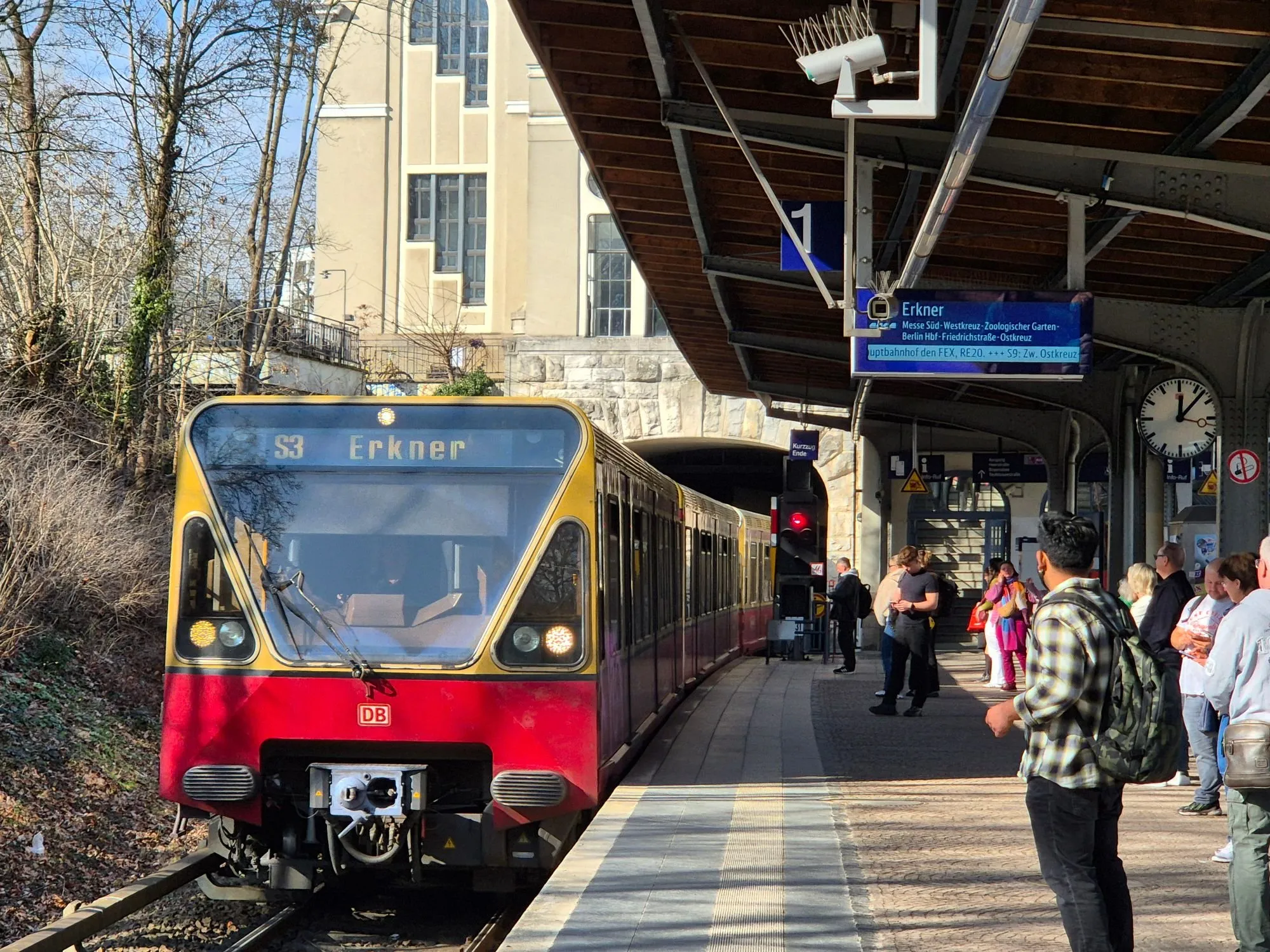 Eine S-Bahn fährt in einen belebten Bahnhof ein