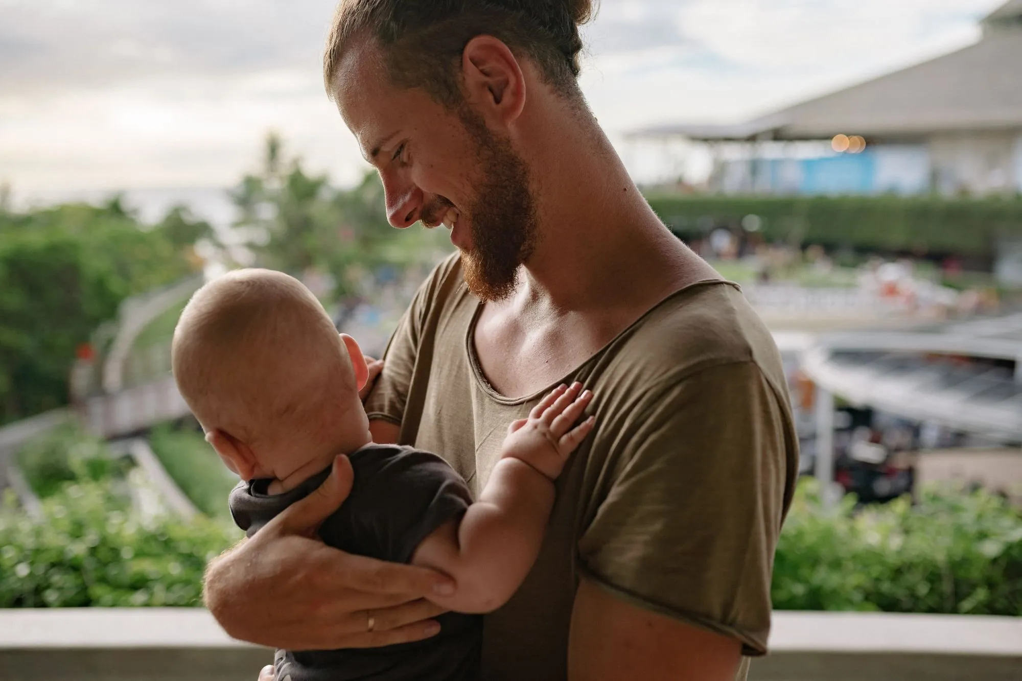 Ein Vater hält lächelnd sein Baby im Arm
